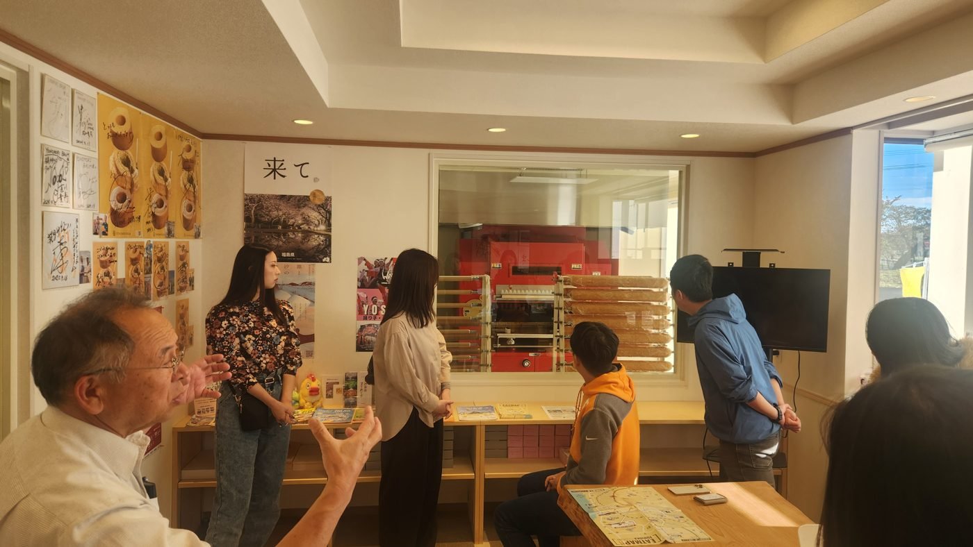 BAUM HOUSE YONOMORI の店内で、遠藤一善さんの話を聞く社員たち